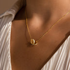 Close-up of the Interlocking Opal Inlay Necklace and Bracelet Set in 18K Gold, worn over a white pleated blouse for a chic, coordinated look.