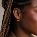 Close-up of a model with a round silver hoop earring, focusing on the jewelry.