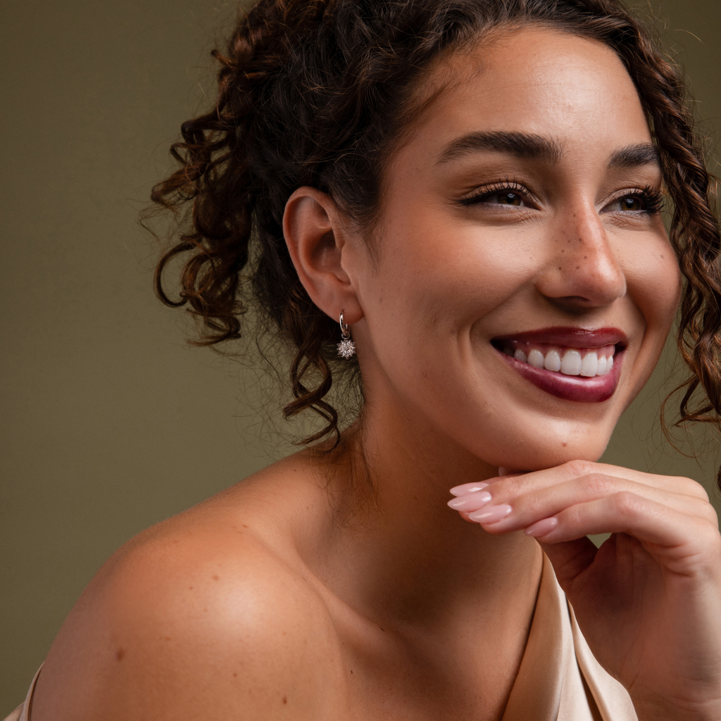 Model showcasing our Diamond Poinsettia Hoops in Silver finish