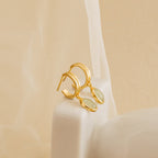 Gold stud hoop earrings with green jade gemstones on a beige background
