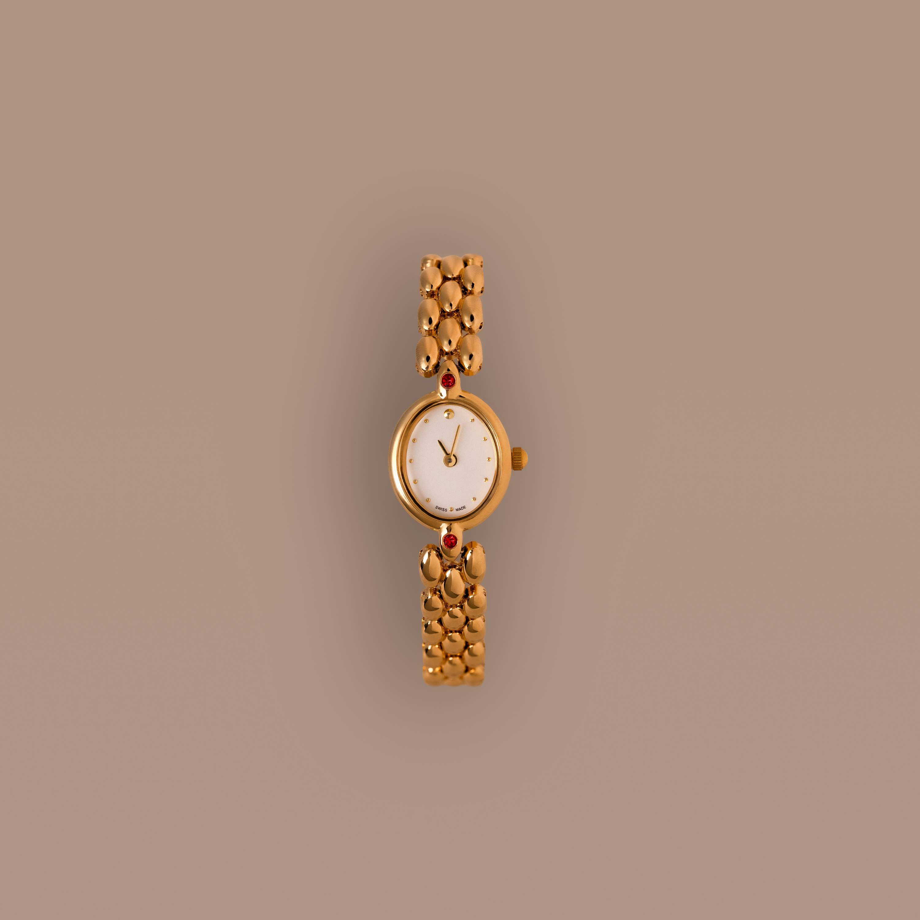 Our Cherry Blossom Timepiece watch with ruby gemstones against a beige background
