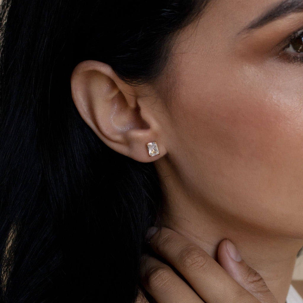 Close-up of a woman wearing a gold diamond earring with a blurred background