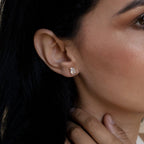 Close-up of a woman wearing a gold diamond earring with a blurred background