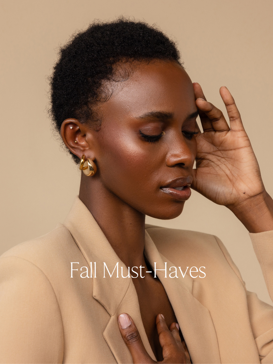 Fall Jewelry feature photo with the text “fall must-haves” featuring a jewelry model wearing 2 dainty stud earrings, 1 huggie hoop earrings and 1 bold chunky teardrop earring.