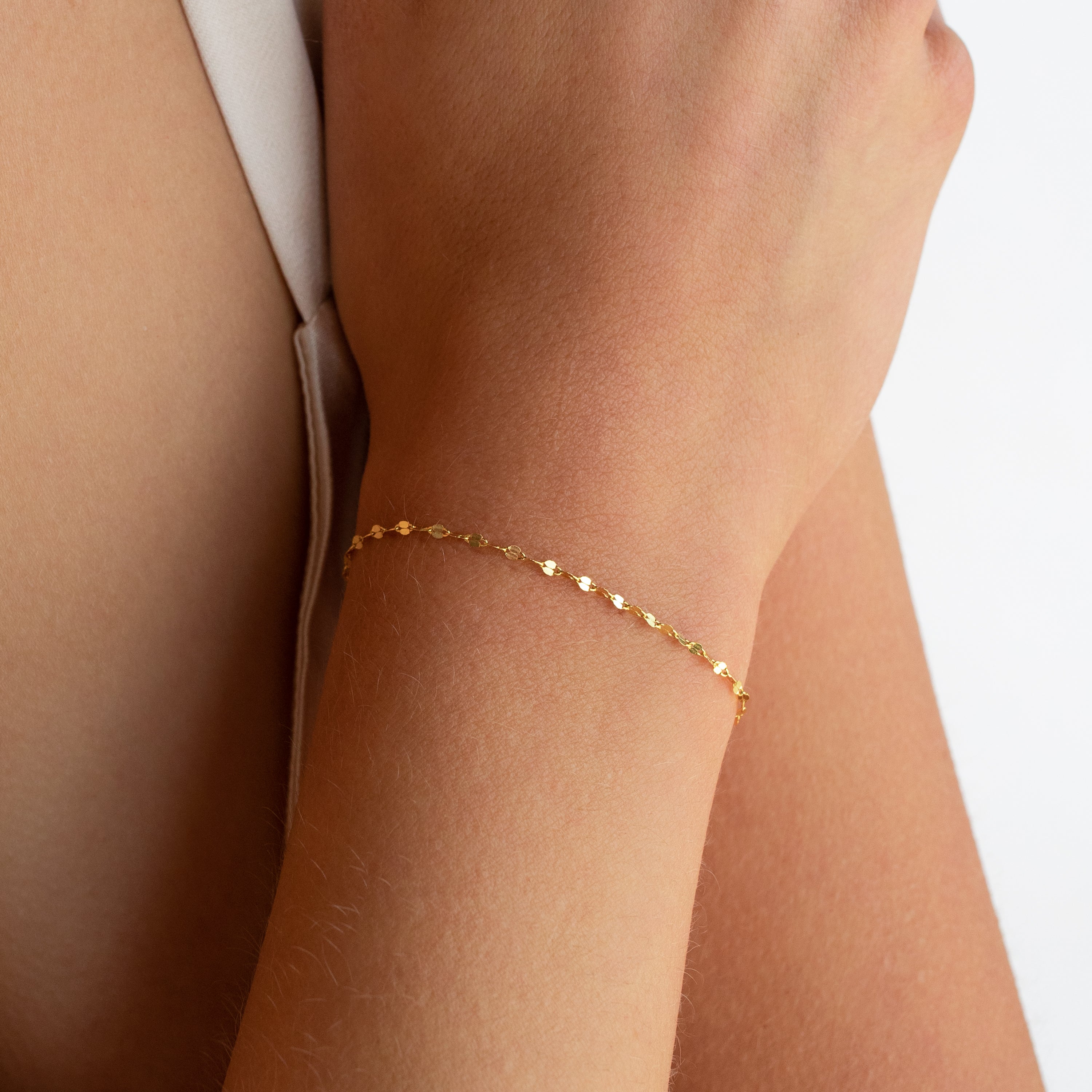 The Josephine Chain Bracelet, crafted in delicate gold, adorns a wrist against a light background.