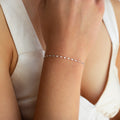 A close-up of a woman's wrist adorned with the Josephine Chain Bracelet, paired with a white sleeveless top.