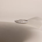 The Art Deco Diamond Ring in Sterling Silver features baguette-cut clear stones in a chandelier-inspired design, elegantly displayed on a soft, neutral background.