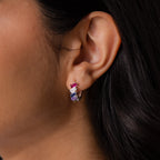 Close-up of a woman’s ear wearing Multiple Tapered Birthstone Huggies in Sterling Silver, featuring vibrant gemstones that add a touch of art deco style.