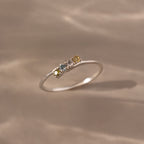 The Multiple Birthstone Curve Ring in Sterling Silver features small multicolored gemstones set in a row, making it ideal for stacking or as a personalized piece of jewelry.