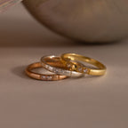 The Diamond Morse Code Ring in Sterling Silver, set with three small diamonds, rests on a beige surface—a meaningful symbol and a stylish accessory for any collection.