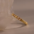 The Diamond Morse Code Ring in 18K Gold features three small diamonds set in a row near a translucent crystal, offering meaningful jewelry that subtly encodes a hidden message.