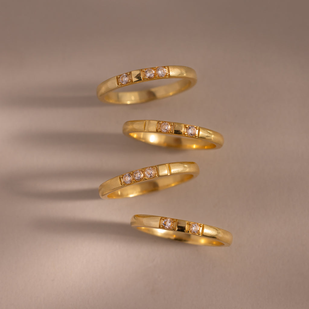 Four Diamond Morse Code Rings in 18K Gold with small, sparkling stones set diagonally on a neutral background—each a meaningful jewelry piece inspired by hidden messages.