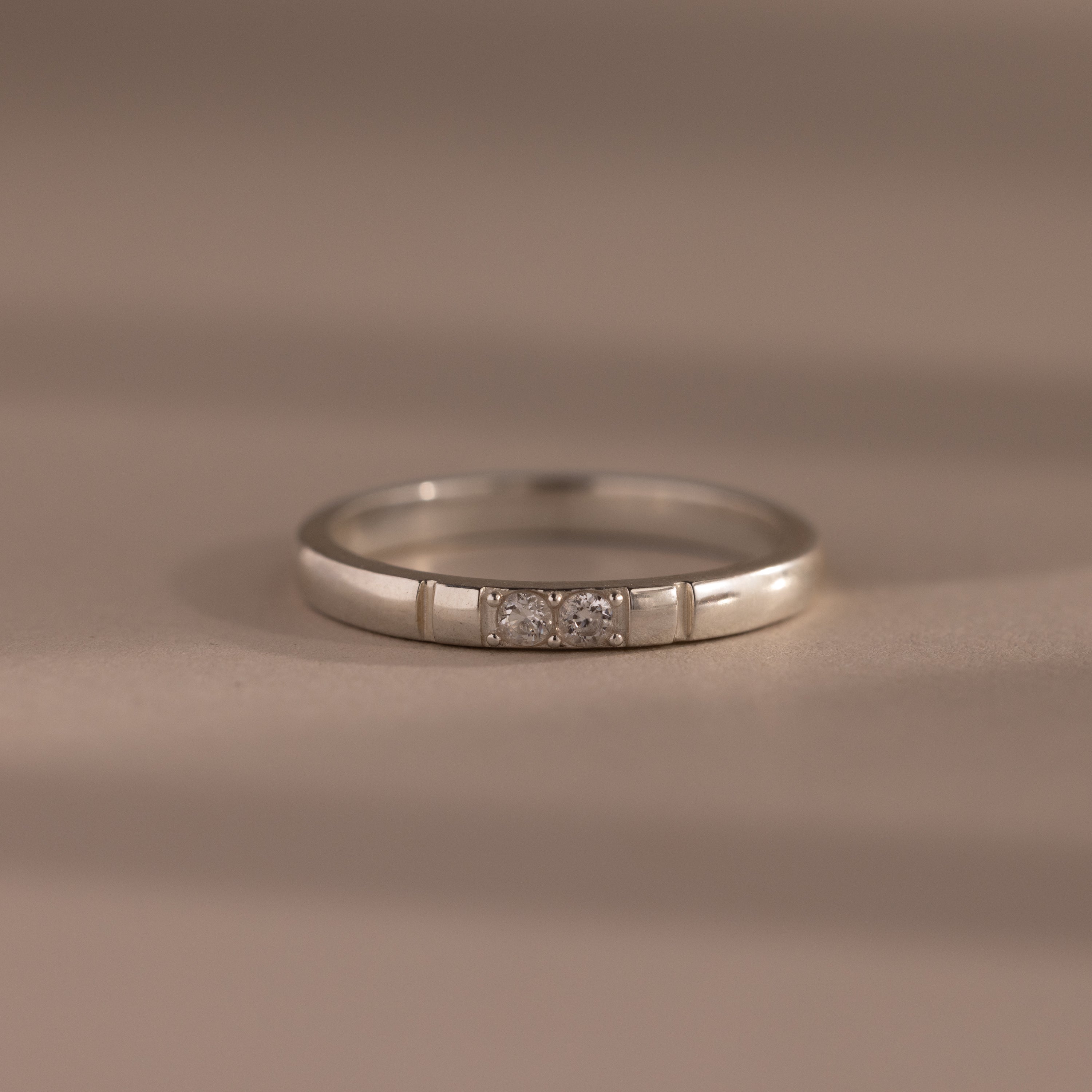 The Diamond Morse Code Ring features three small center diamonds set in silver, showcased on a neutral background.