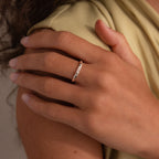 A hand with neatly manicured nails wears the Diamond Morse Code Ring in Sterling Silver, its delicate stones forming a hidden message as it rests gently on a shoulder.