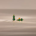 Ombre Emerald Flatback Studs with three round green gemstones on gold, shown on a smooth neutral surface—an elegant pick for fans of personalized jewelry.