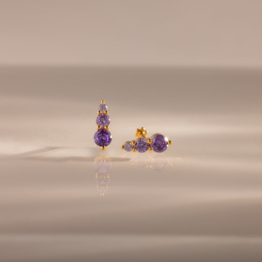 Ombre Alexandrite Flatback Studs with small round purple stones, displayed on a reflective beige surface—a stylish personalized gift ideal for any occasion.