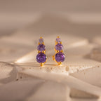 Ombre Alexandrite Flatback Studs with three purple gemstones, shown on a textured light surface—perfect as a personalized gift or stylish studs.