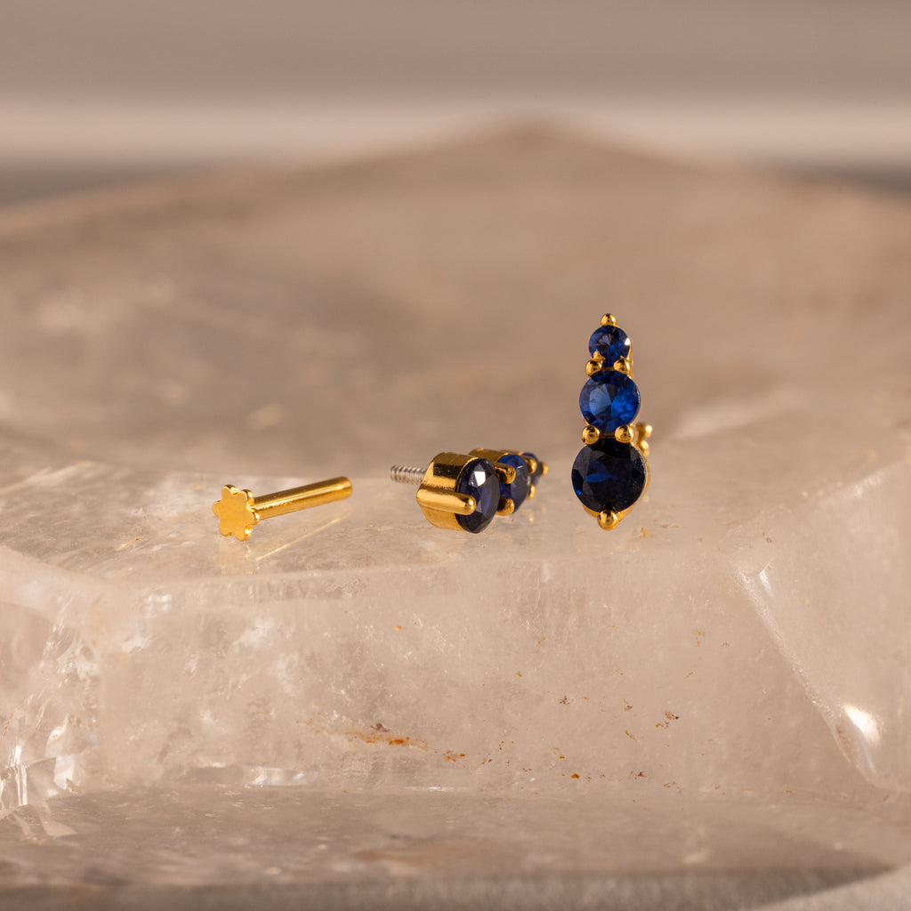 Ombre Sapphire Flatback Studs featuring three blue gemstones in a gradient design, shown on a clear textured surface.