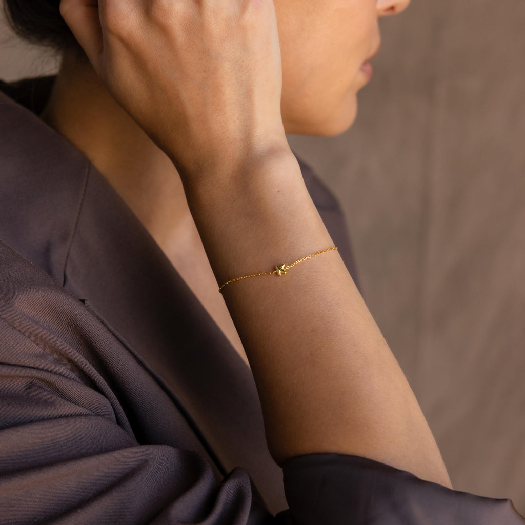 Model wearing a dainty gold 3D bubble initial K chain bracelet.