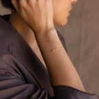 Model wearing a dainty gold 3D bubble initial K chain bracelet.