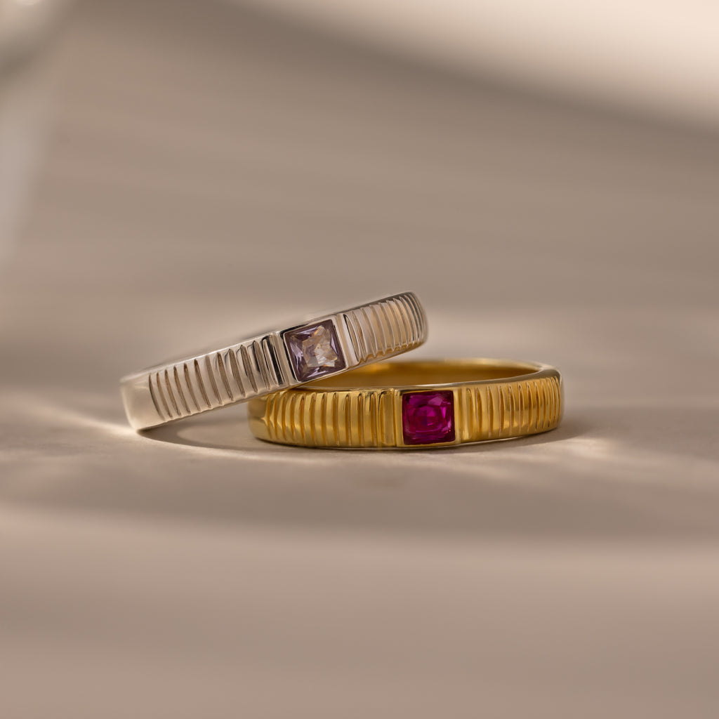 The Ribbed Alexandrite Band, a ribbed ring featuring a lab-created alexandrite stone, is displayed on a neutral background.