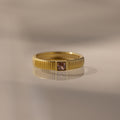 The Ribbed Pink Tourmaline Band is a gold stacking ring with a textured pink tourmaline band and a small square gemstone, making it an elegant choice for a birthstone ring.