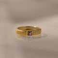 The Ribbed Alexandrite Band showcases a square-cut alexandrite center stone, offering elegant birthstone style against any backdrop.