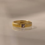 The Ribbed Alexandrite Band showcases a square-cut alexandrite center stone, offering elegant birthstone style against any backdrop.