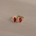 Multiple Marquise Birthstone Ring in 18K Gold features three marquise stones—two red flanking a pink—set on a beige background, making it an elegant, personalized addition to your jewelry collection.