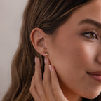 Woman with long brown hair and natural makeup touches her ear, wearing elegant Marquise Pink Tourmaline & Pearl Studs.