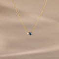 Teardrop Blue Zircon & Pearl Necklace with a small pearl and blue zircon pendant, ideal as a milestone gift, showcased on a soft beige background.