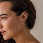 Model wearing butterfly jacket earrings, styled in two piercings with the butterfly piece in the lower lobe and a crystal stud above.