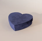 Closed blue velvet heart-shaped jewelry box with soft texture, displayed on a neutral background.