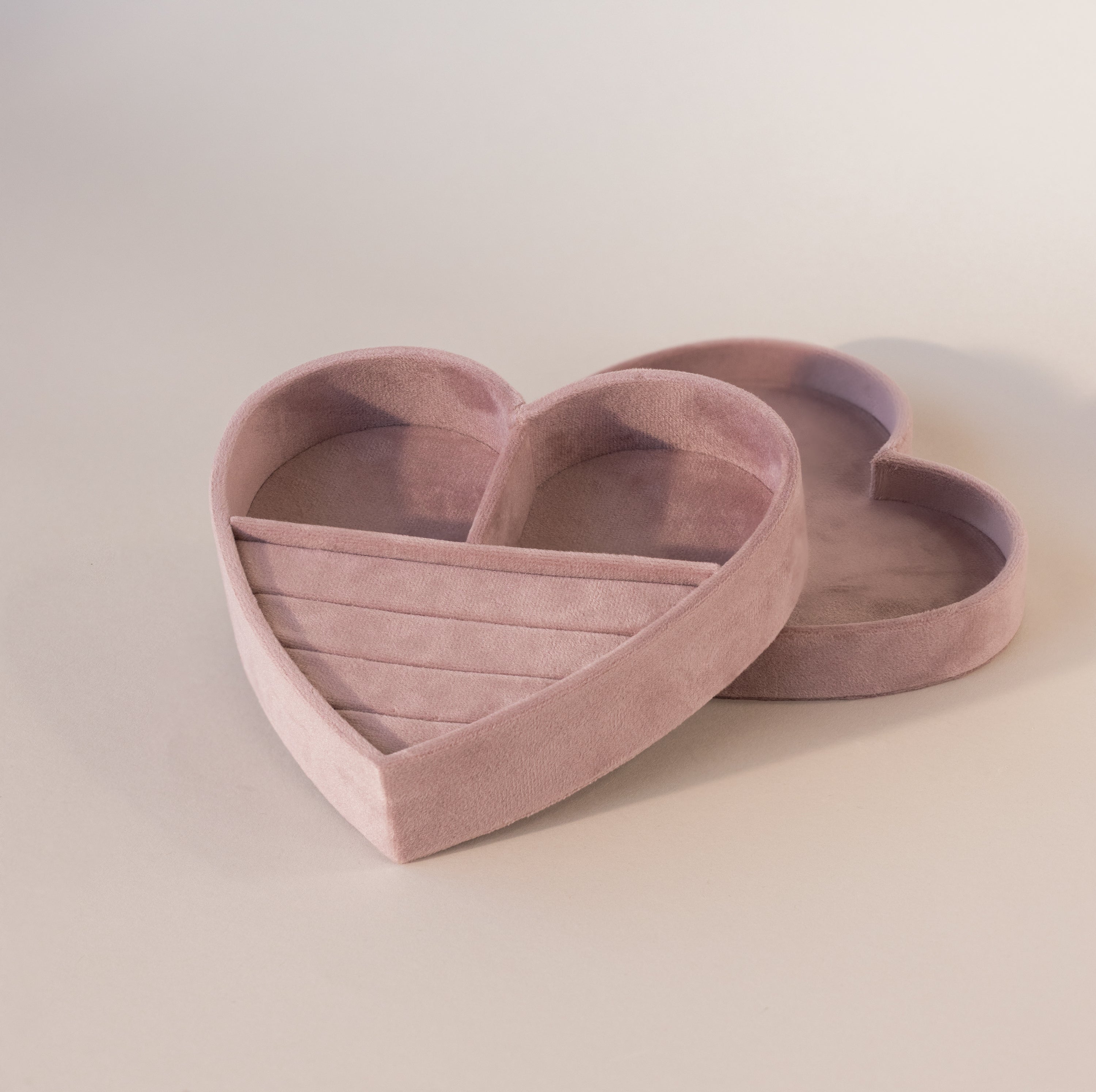 Empty heart-shaped velvet jewelry box in lavender with ring slots and compartments, shown with matching lid beside it.