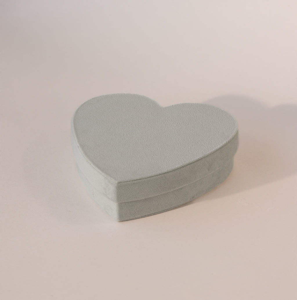 Closed mint green velvet heart-shaped jewelry box with soft texture, displayed on a neutral background.