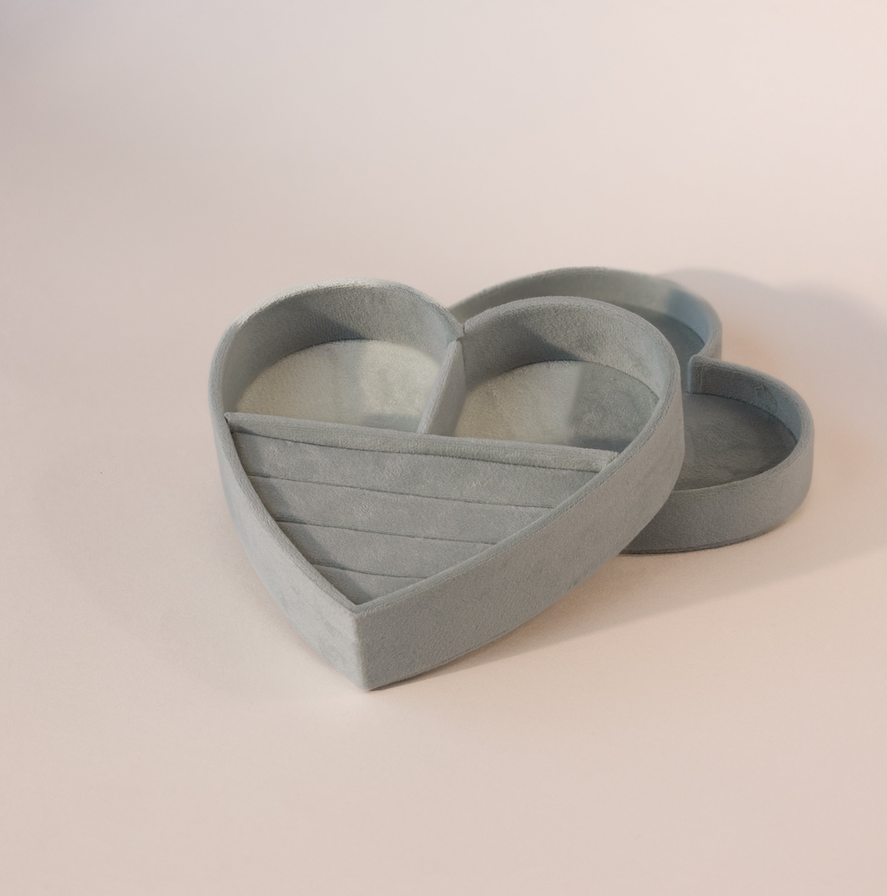 Mint green velvet heart-shaped jewelry box with lid, featuring ring slots and compartments on a neutral background.