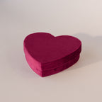 Closed red velvet heart-shaped jewelry box with soft texture, displayed on a neutral background.