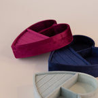 Velvet heart-shaped jewelry boxes in red, blue, and mint green, each with ring slots and compartments.