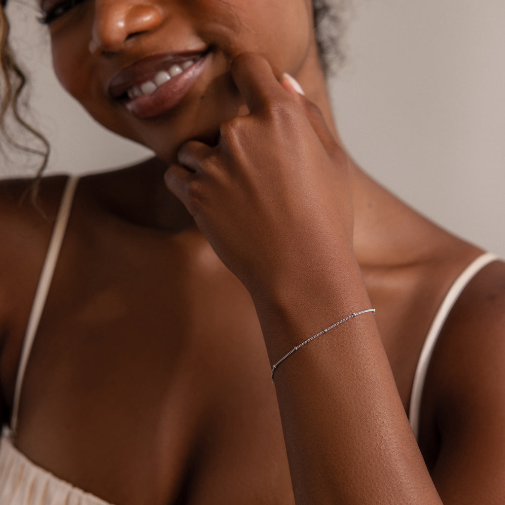Woman wearing a delicate beaded silver bracelet on her wrist