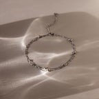 Silver Beaded Anklet on a textured beige surface