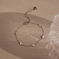 Heart Station Bracelet in Sterling Silver with small heart charms on a soft, neutral backdrop—a romantic, versatile piece and perfect stackable bracelet for any occasion.