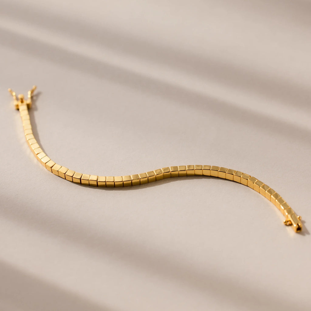 The Cube Bracelet showcases geometric bead links with a wavy design, displayed on a neutral beige background—an ideal statement piece for men.