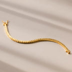 The Cube Bracelet showcases geometric bead links with a wavy design, displayed on a neutral beige background—an ideal statement piece for men.