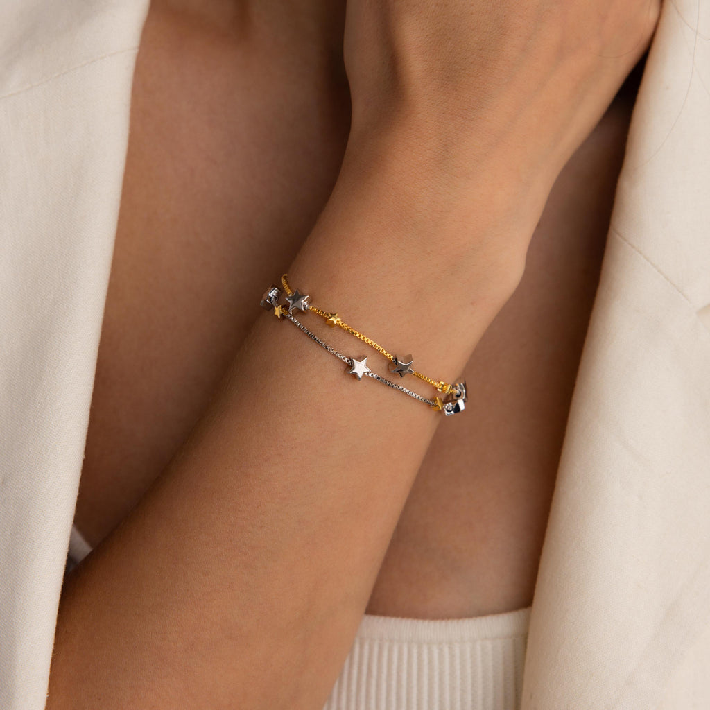 Model wearing Mixed Metal Star Bracelet with the gold chain on top.