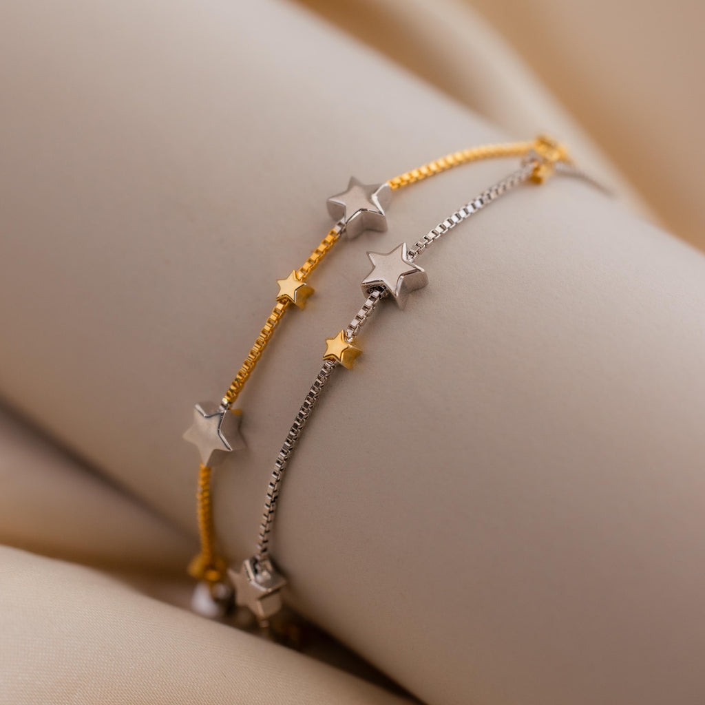 Close up of Mixed Metal Star Bracelet laid on a curved tube to showcase the design.