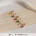 Ten vibrant Dainty Baguette Birthstone Bracelets with colorful rectangular charms are lined up on a light surface—each minimalist piece is perfect for stacking.