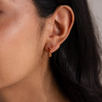 Close-up of a woman's ear wearing Geometric Birthstone Huggies, ideal for pairing with birthstone jewelry or diamond accents for a personalized touch.