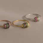 The Multiple Birthstone Bead Ring in Rose Gold features colorful gemstone-studded spinning bands, making it a unique and personalized jewelry statement or birthstone ring for any occasion.