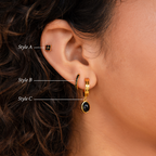 Close-up of a woman's ear with three gold earrings from the Onyx Diamond Earrings Set, featuring elegant details like Black Gemstone Drop Hoops and Black Flower Studs.