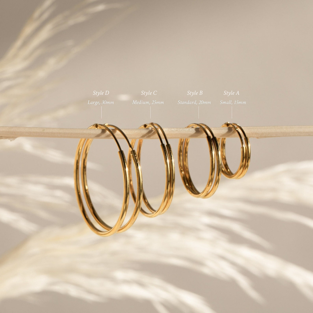 The Endless Thin Hoops feature four graduated sizes on a sleek rod, labeled from small to large—a timeless earring style and perfect for everyday wear.